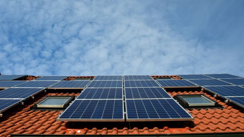 A picture of solar panels lying on an orange roof.