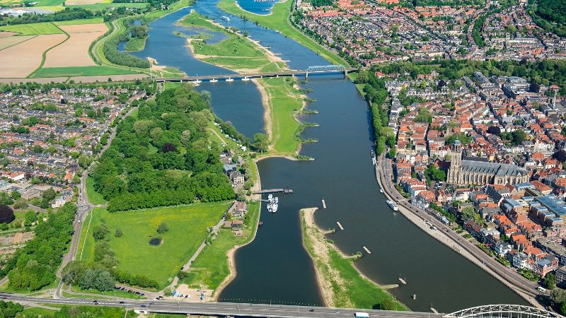 Een luchtfoto van Deventer. Je ziet veel gebouwen en de IJssel.