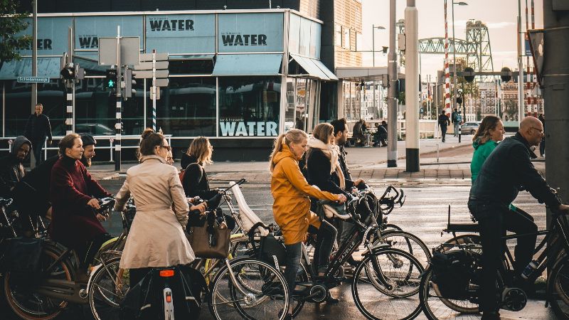 Cyclists in the city waiting at a traffic light.