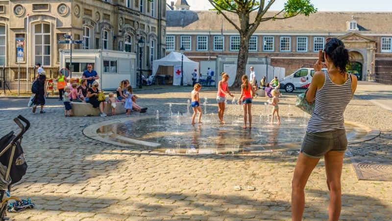 Kinderen die spelen onder een fontein in de zomer.