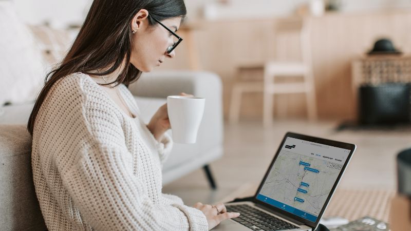 A woman with her laptop on her lap. She is looking at her screen which shows an YourView environment.