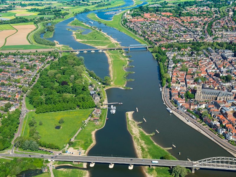 Een luchtfoto van Deventer. Je ziet veel gebouwen en de IJssel.