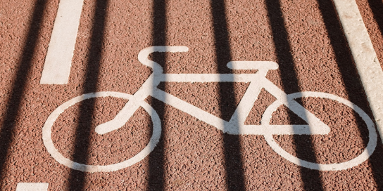A white signed bicycle on the road.