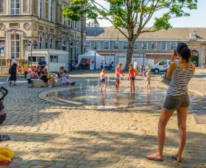 Children playing under a fountain in summer.