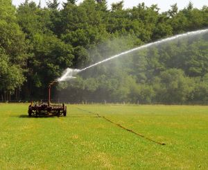 Een weiland dat wordt gesproeid met water.
