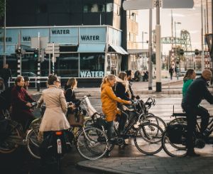 Cyclists in the city waiting at a traffic light.