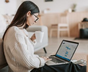 A woman with her laptop on her lap. She is looking at her screen which shows an YourView environment.