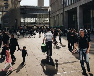 Many people walk across a square in the city.