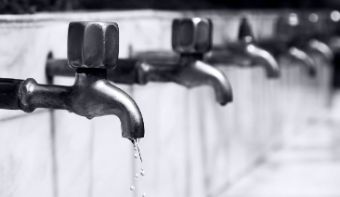 Several water taps. Water flows out of the front one.