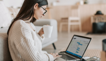 A woman with her laptop on her lap. She is looking at her screen which shows an YourView environment.