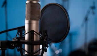 A photo of a microphone with a blue background.